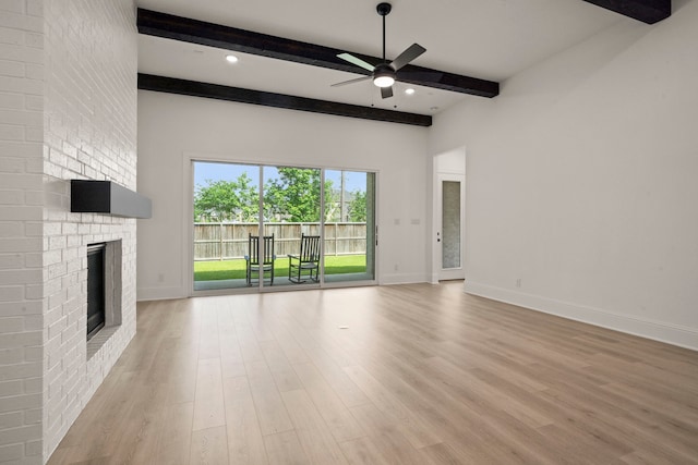 1222 Tallow Park Ln, Pinehurst, TX 77362 - unfurnished living room with beam ceiling, ceiling fan, light wood-type flooring, baseboards, and a fireplace