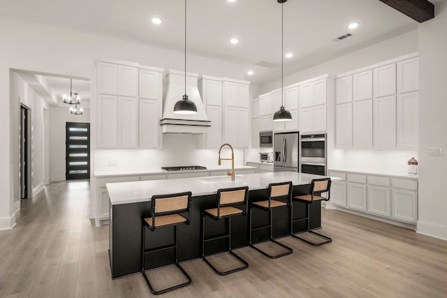 1222 Tallow Park Ln, Pinehurst, TX 77362 - kitchen with a sink, stainless steel appliances, custom exhaust hood, light wood-type flooring, and recessed lighting