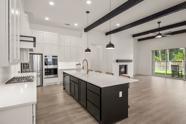 1222 Tallow Park Ln, Pinehurst, TX 77362 - kitchen with a sink, open floor plan, appliances with stainless steel finishes, white cabinetry, and recessed lighting