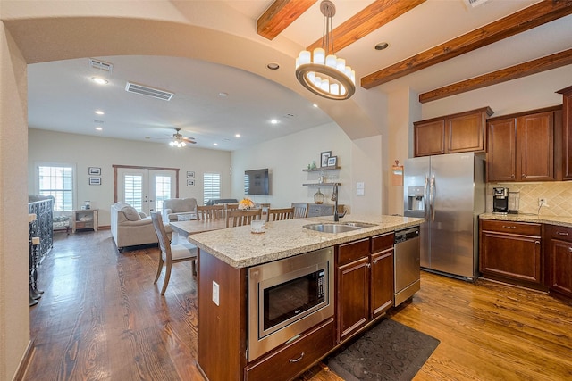 kitchen featuring appliances with stainless steel finishes, a sink, dark wood-style floors, visible vents, and pendant lighting