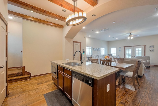 kitchen with recessed lighting, a sink, arched walkways, appliances with stainless steel finishes, and wood finished floors