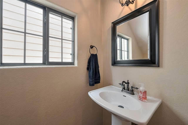 bathroom featuring a textured wall and a sink
