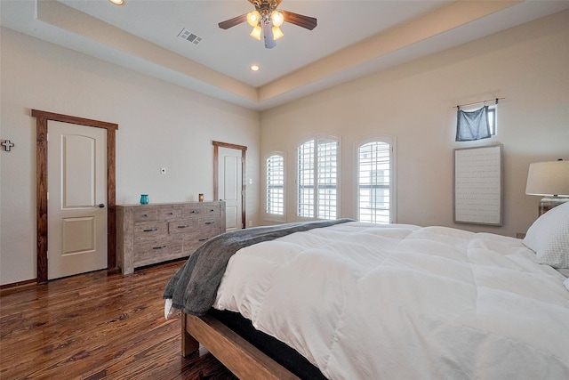 bedroom featuring recessed lighting, ceiling fan, dark wood-style floors, visible vents, and a raised ceiling