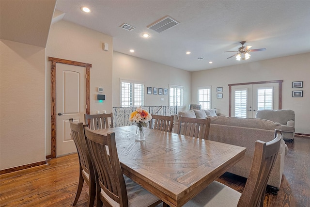dining room with a ceiling fan, visible vents, and wood finished floors