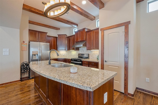 kitchen featuring baseboards, appliances with stainless steel finishes, backsplash, a sink, and beam ceiling