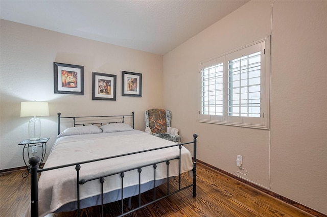 bedroom featuring wood finished floors and baseboards
