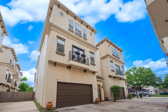 mediterranean / spanish-style home featuring fence, driveway, stucco siding, and a garage