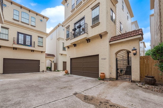 view of front facade with concrete driveway, stucco siding, a tiled roof, and an attached garage