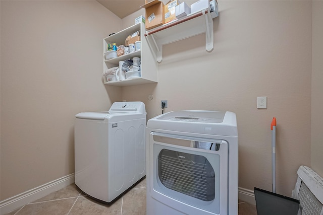 laundry room featuring light tile patterned floors, washer and dryer, laundry area, and baseboards