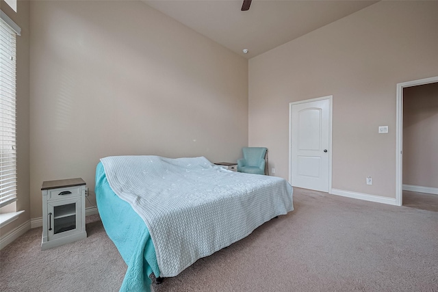 carpeted bedroom featuring baseboards, high vaulted ceiling, and a ceiling fan