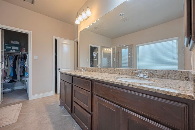 full bath featuring visible vents, a stall shower, double vanity, and a sink