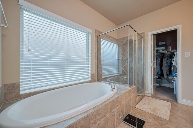 full bath featuring a walk in closet, a shower stall, and plenty of natural light