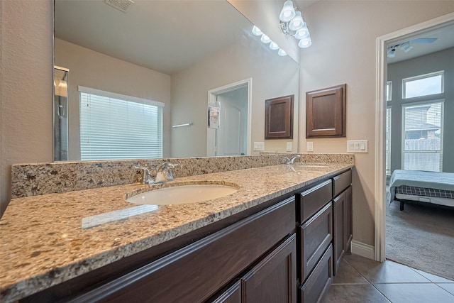 full bathroom with tile patterned flooring, a sink, double vanity, and ensuite bath