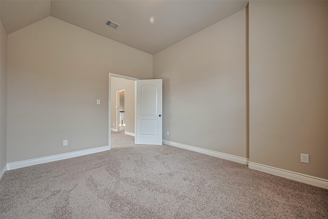 carpeted spare room featuring visible vents, high vaulted ceiling, and baseboards