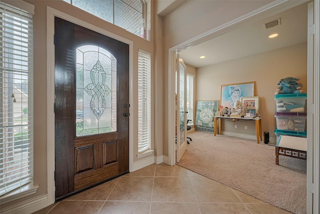 tiled entrance foyer featuring baseboards, visible vents, carpet floors, and recessed lighting