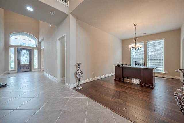 entryway with baseboards, a notable chandelier, and dark tile patterned floors