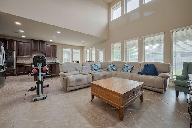 living room featuring light tile patterned floors, visible vents, recessed lighting, and a high ceiling