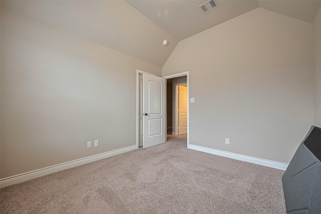 spare room featuring lofted ceiling, carpet, visible vents, and baseboards