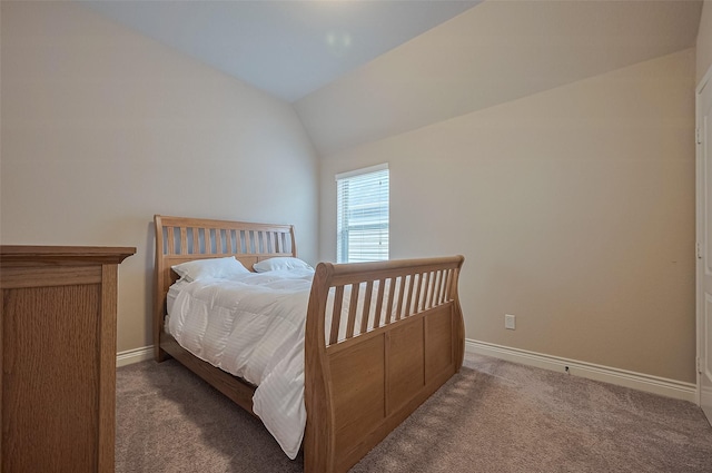 carpeted bedroom with lofted ceiling and baseboards