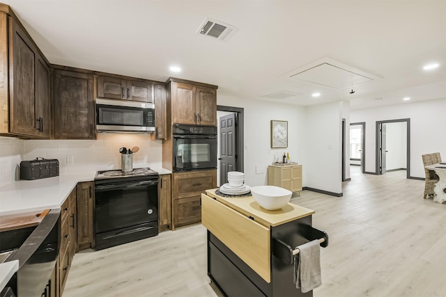 kitchen with dark brown cabinetry, light wood-style floors, black appliances, backsplash, and visible vents