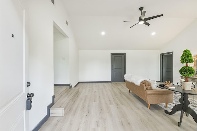 living area featuring ceiling fan, visible vents, baseboards, light wood-type flooring, and vaulted ceiling