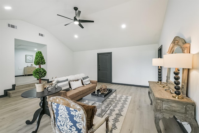 living area featuring lofted ceiling, visible vents, a ceiling fan, and light wood-style flooring