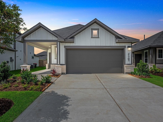 21703 White Bellflower Ln, Cypress, TX 77433 - view of front of home featuring board and batten siding, an attached garage, driveway, and a shingled roof