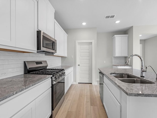 21703 White Bellflower Ln, Cypress, TX 77433 - kitchen with appliances with stainless steel finishes, light stone counters, recessed lighting, decorative backsplash, and white cabinetry