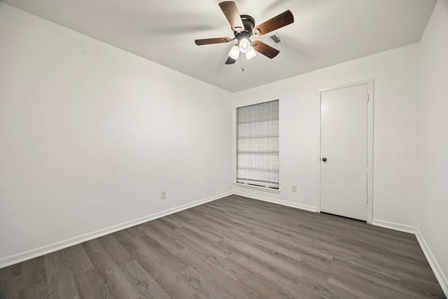unfurnished bedroom with dark wood-type flooring, a ceiling fan, and baseboards