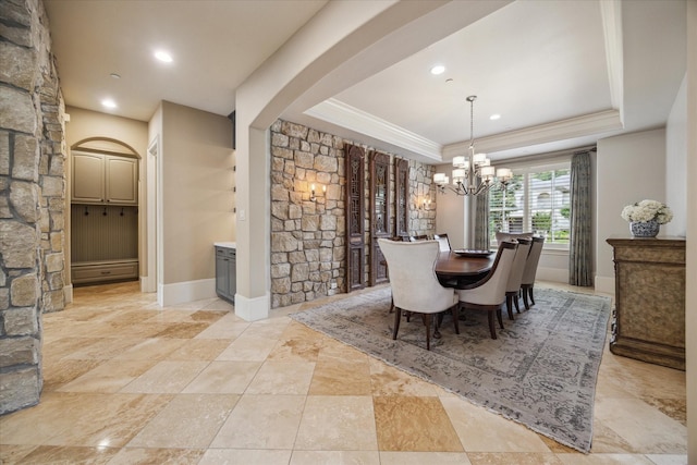 dining space featuring crown molding, arched walkways, a raised ceiling, a notable chandelier, and recessed lighting