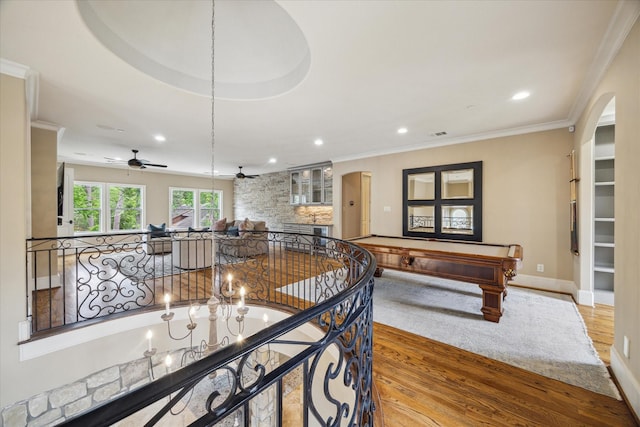 interior space featuring arched walkways, a ceiling fan, and wood finished floors