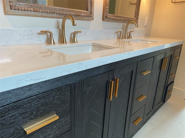 full bath with tile patterned floors, double vanity, and a sink