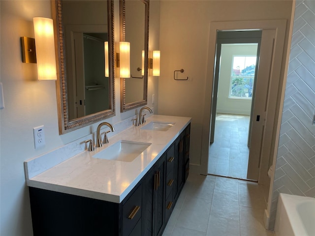 bathroom with tile patterned floors, a bathing tub, double vanity, and a sink