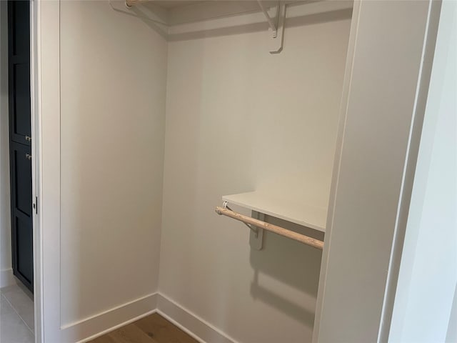 walk in closet with wood finished floors