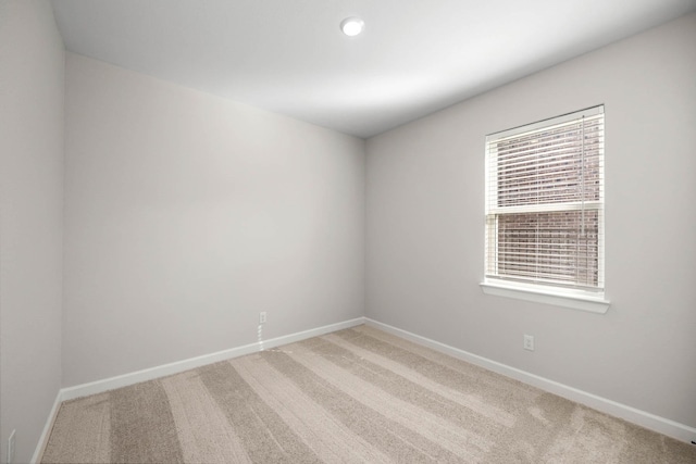 spare room featuring baseboards and carpet floors