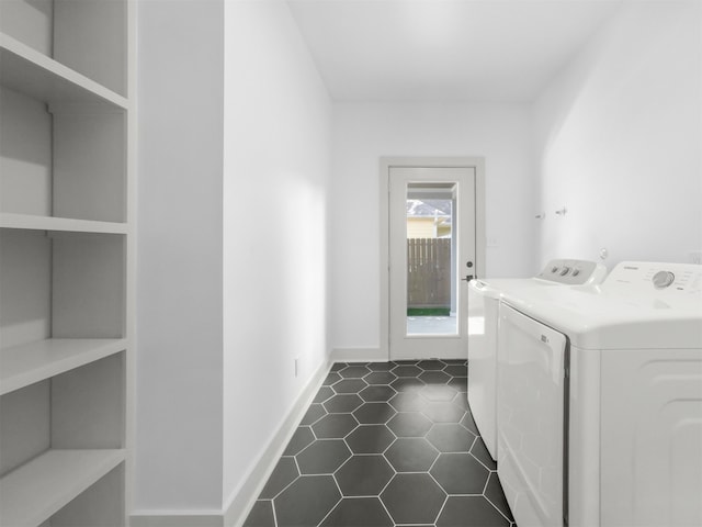 laundry area with baseboards, dark tile patterned floors, laundry area, and washing machine and dryer