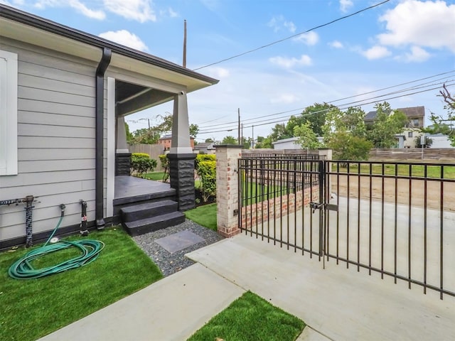 view of gate with fence and a yard