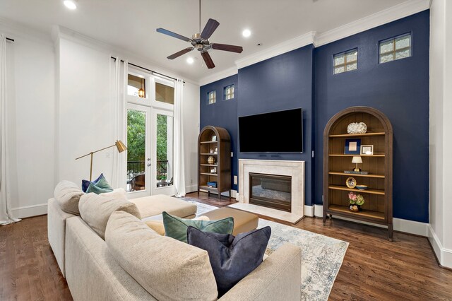 living room featuring crown molding, a ceiling fan, baseboards, and a premium fireplace