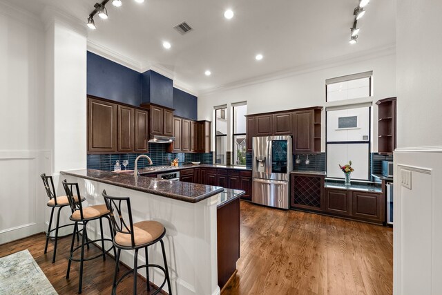 kitchen with visible vents, open shelves, stainless steel fridge with ice dispenser, a peninsula, and ornamental molding
