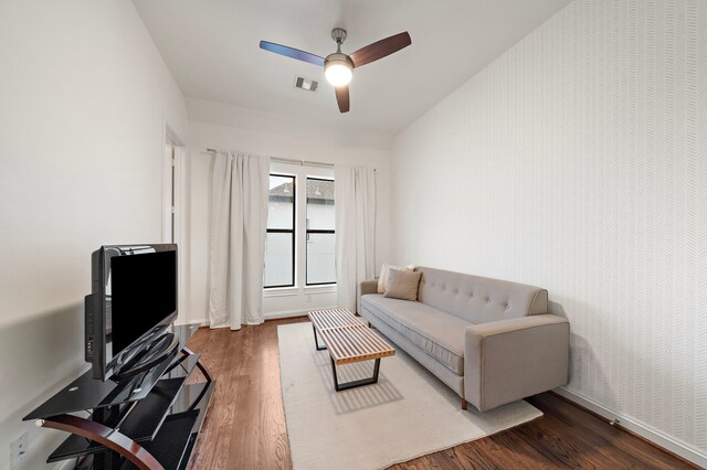 living area featuring baseboards, ceiling fan, visible vents, and wood finished floors