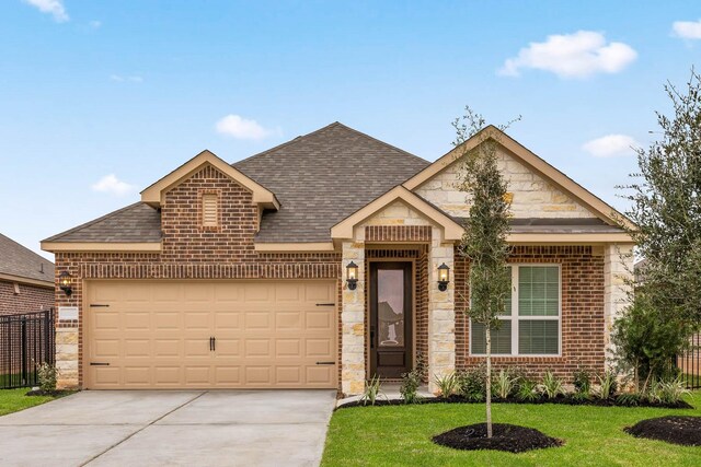 view of front of property featuring driveway, roof with shingles, an attached garage, brick siding, and a front lawn