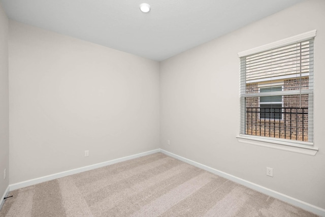 carpeted spare room featuring baseboards