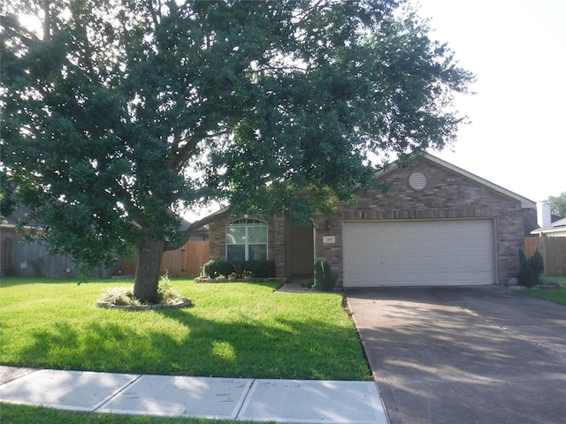 view of front of property with a front yard, fence, brick siding, and aphalt driveway