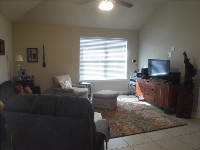 living area with light tile patterned floors, a ceiling fan, vaulted ceiling, and baseboards