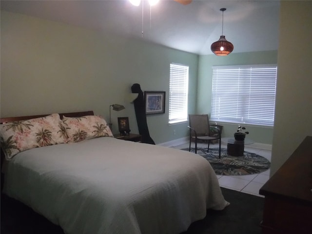 bedroom featuring tile patterned flooring, vaulted ceiling, and baseboards