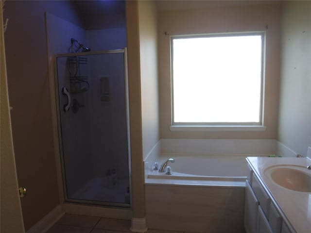 bathroom with tile patterned floors, a stall shower, a bath, and vanity