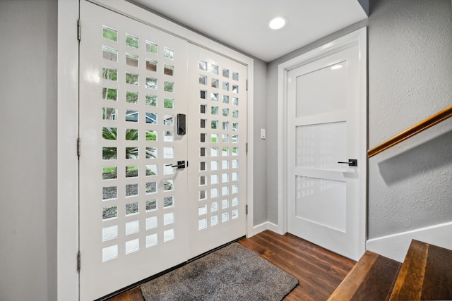 foyer featuring baseboards and dark wood-type flooring