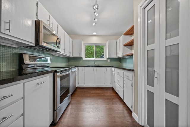 kitchen featuring dark wood-style floors, dark countertops, appliances with stainless steel finishes, and a sink