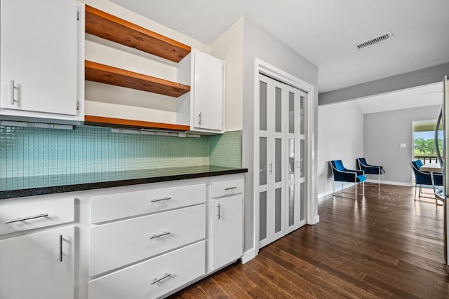 kitchen featuring tasteful backsplash, open shelves, dark countertops, visible vents, and dark wood-style flooring
