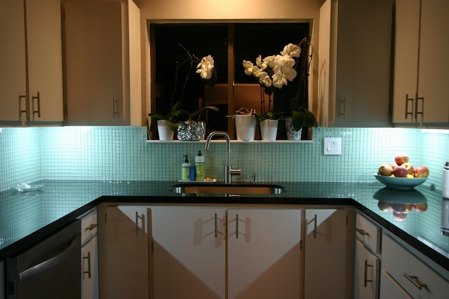 kitchen featuring tasteful backsplash, dishwasher, white cabinets, and a sink